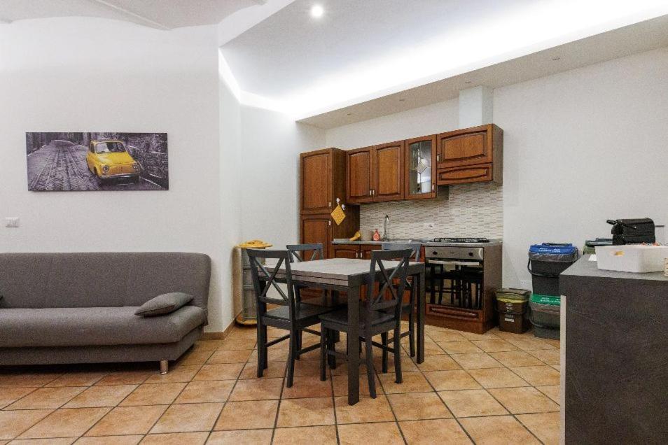 ein Wohnzimmer mit einem Tisch und einem Sofa sowie eine Küche in der Unterkunft La casa di Bianca in Piediluco