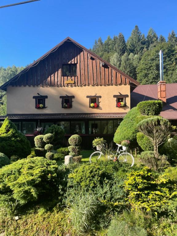 un gran edificio con árboles y arbustos delante de él en Ranczo Frodyma, en Stronie Śląskie