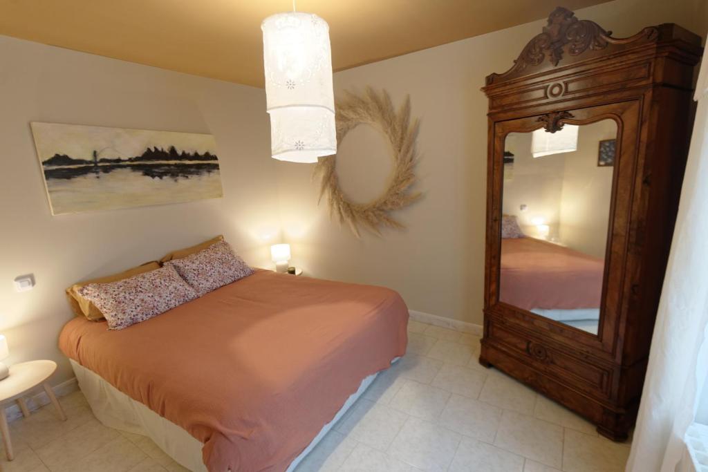1 dormitorio con cama y espejo grande en La Boisselée, en Saint-Dyé-sur-Loire