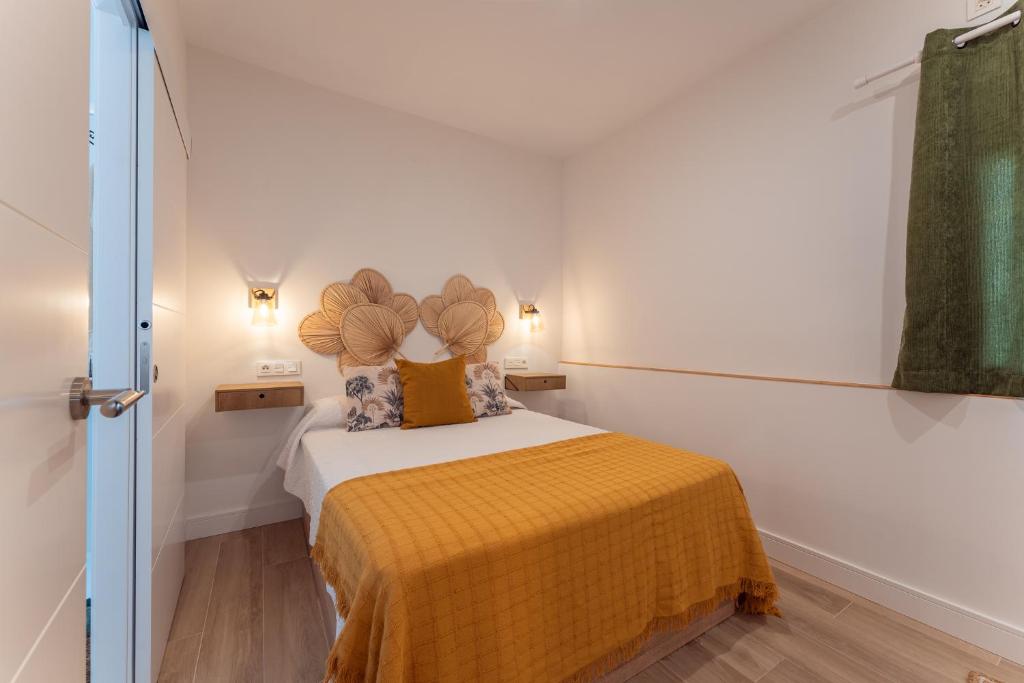 Dormitorio pequeño con cama con manta amarilla en Apartamento Turístico KHöALA HOME en Merida