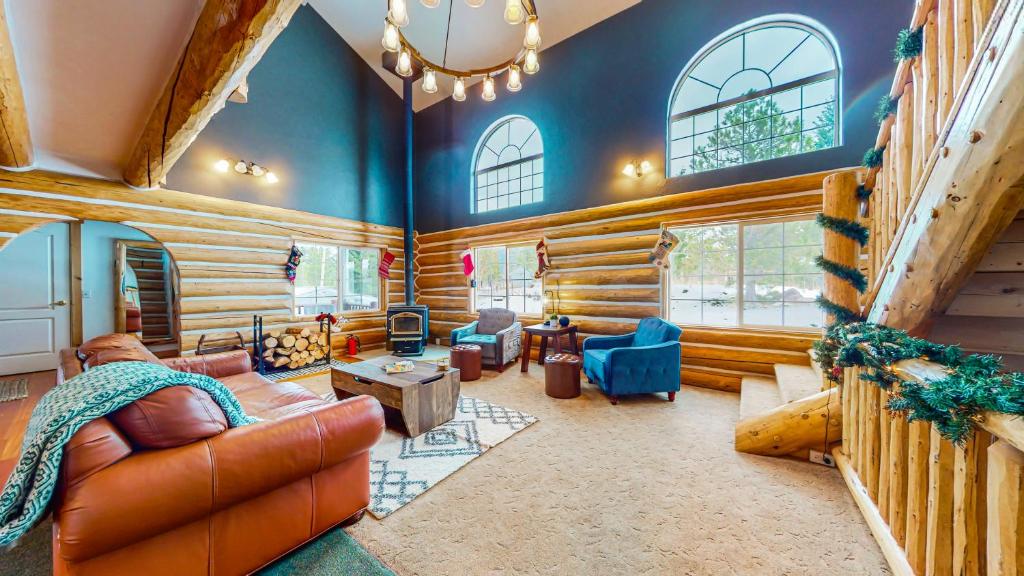 een woonkamer met lederen meubels en houten wanden bij Glacier Dream Escape in Coram