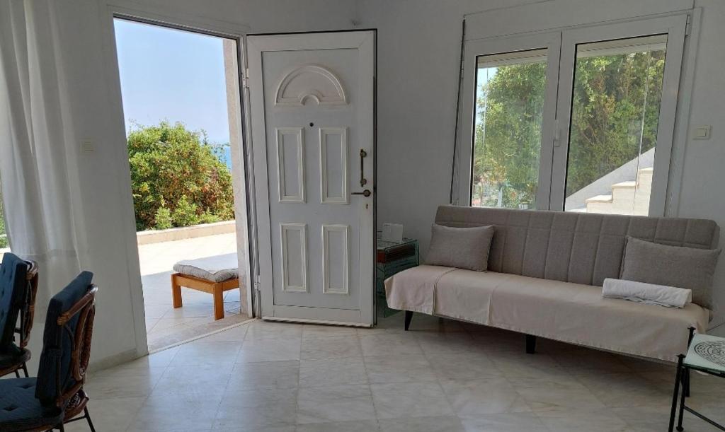 a living room with a couch in front of a door at Seaview dreams in Ormos Panagias