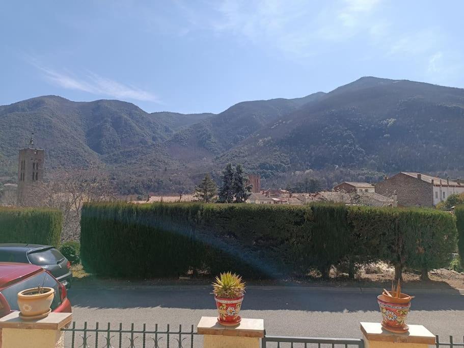 un coche aparcado en un estacionamiento con montañas en el fondo en F2 classé 3 étoiles vue montagne, extérieur clos en Arles-sur-Tech