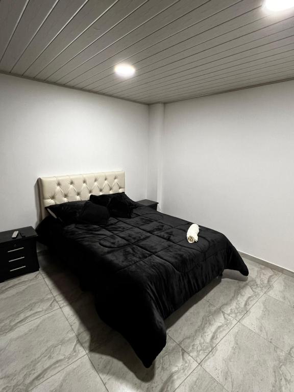 um quarto com uma grande cama preta num quarto em Prívate apt- 2 BTH - 2BTR- 1KTC em Paipa