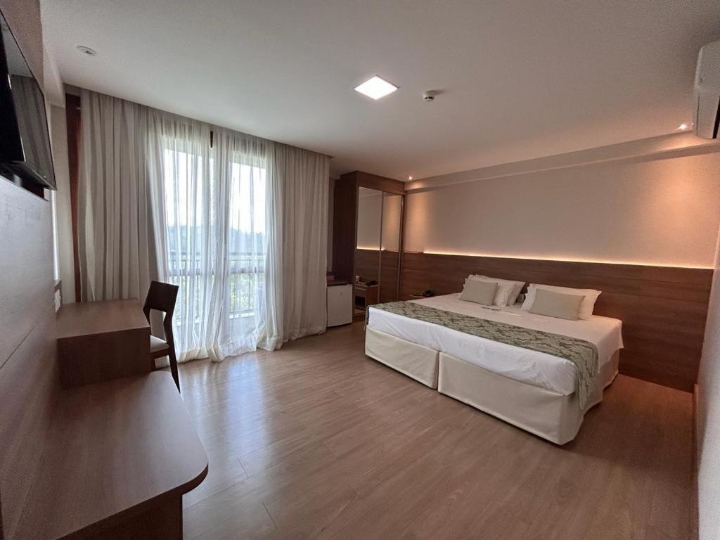 una camera d'albergo con letto e finestra di Vista Azul Hotel a Domingos Martins