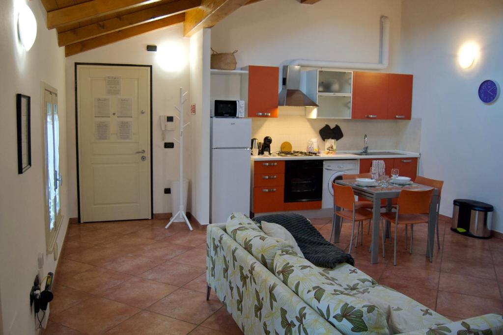 uma sala de estar com um sofá, uma mesa e uma cozinha em CASA VIOLA, deliziosa mansarda in centro storico em Módena