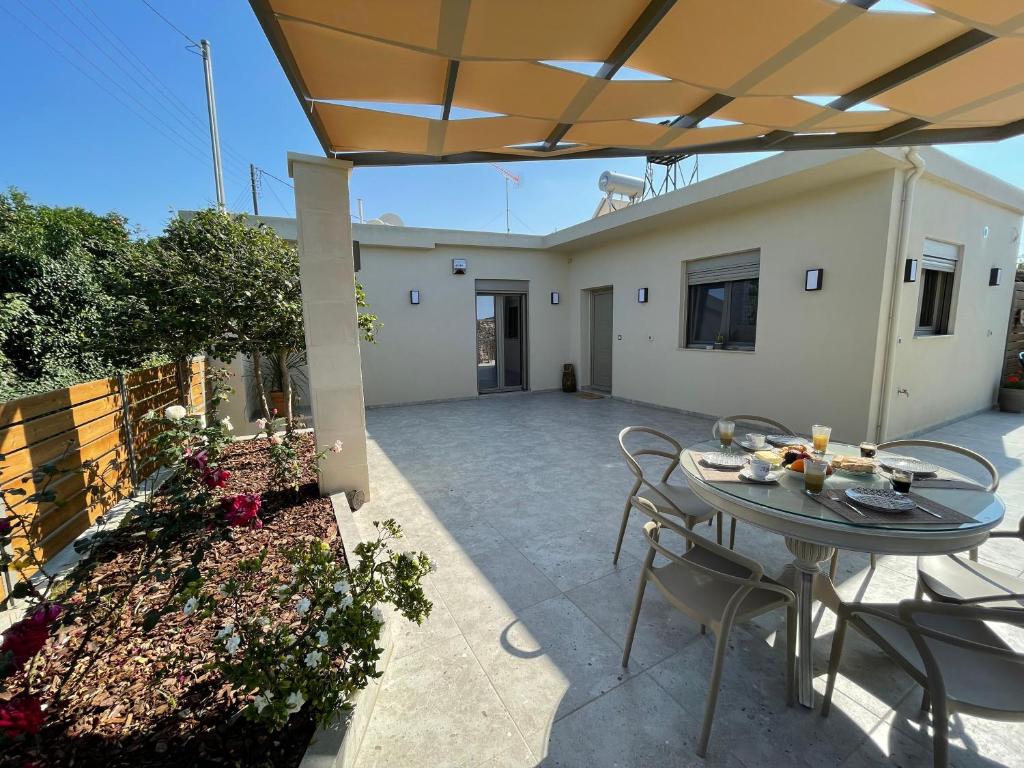 a patio with a table and chairs and a house at Aryiro's Residence,Cozy&Sunny in Alikianós