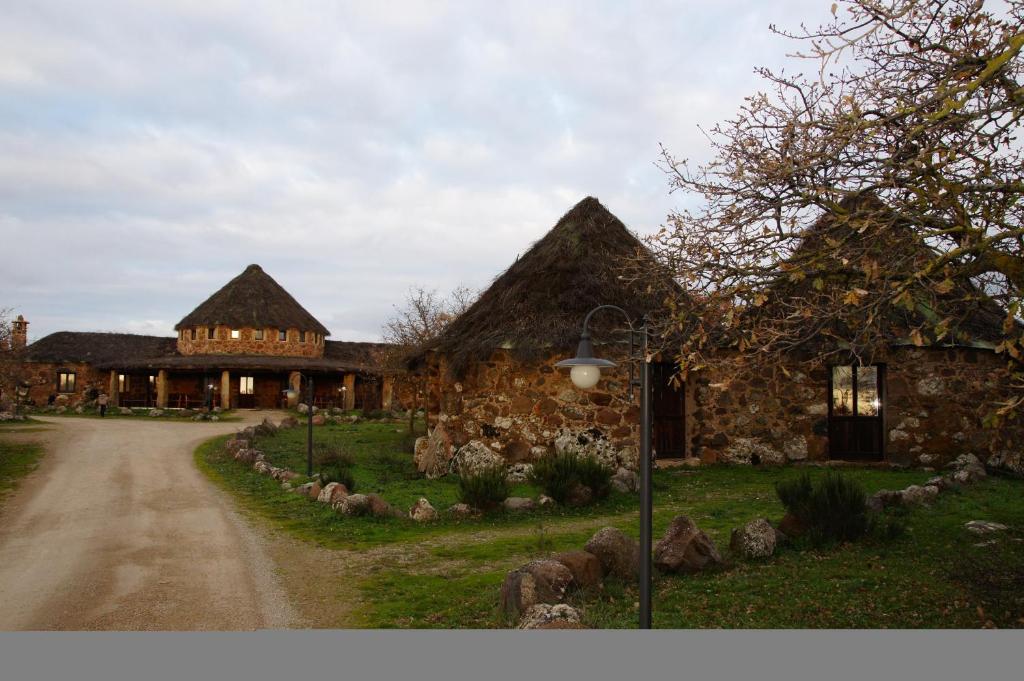 um grande edifício de pedra com uma estrada em frente em Villaggio Antichi Ovili em Orroli