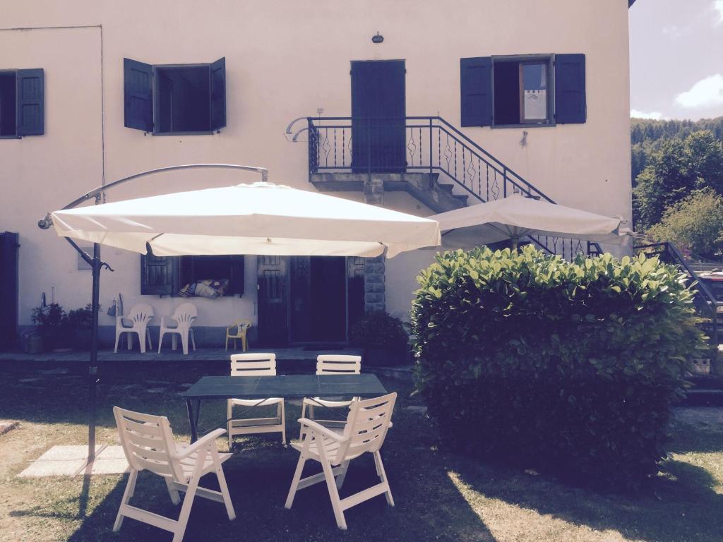 a patio with a table and chairs and an umbrella at Appartamenti Bice Abetone in Abetone