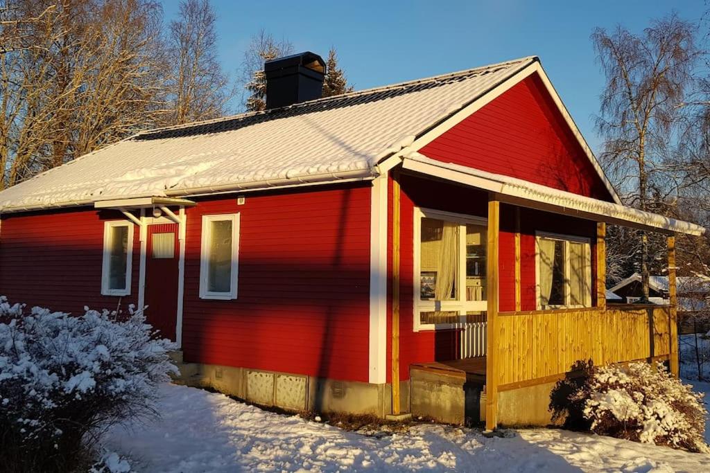 mały czerwony dom ze śniegiem na ziemi w obiekcie Hus nära sjö och säfsenresort w mieście Fredriksberg