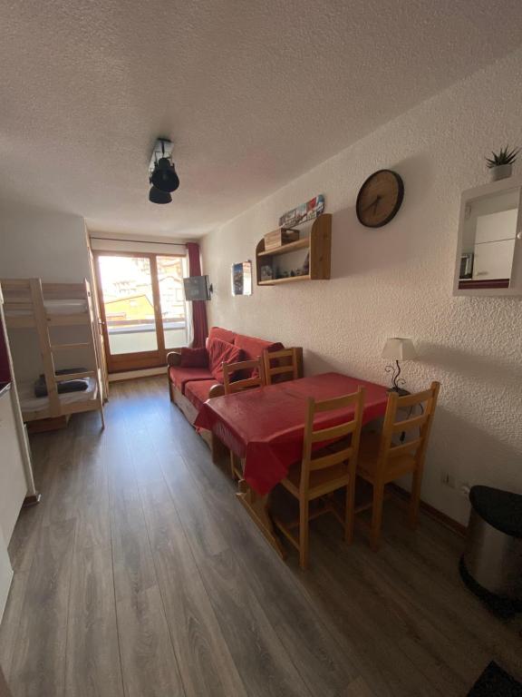 a living room with a table and a couch at Charmant T2 montagne en étage élevé. in Val Thorens