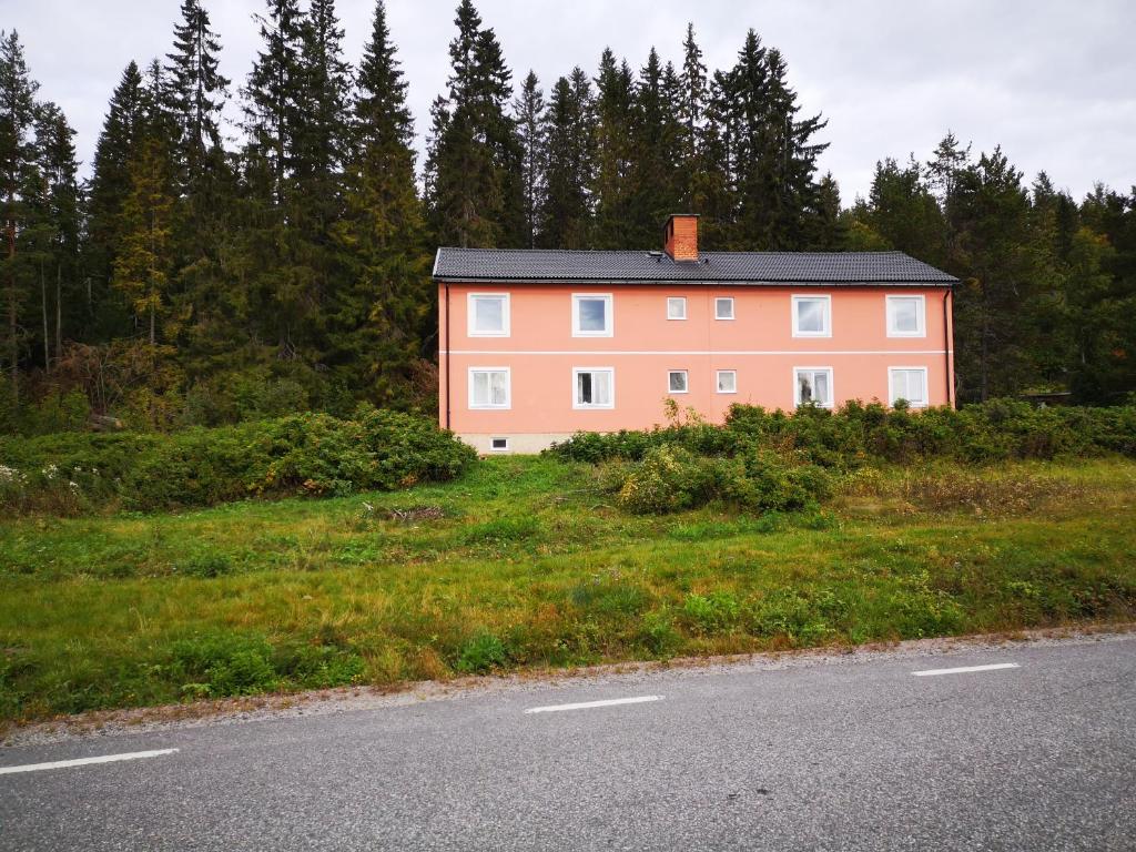 a pink house on the side of a road at Lagfors128 in Ljustorp