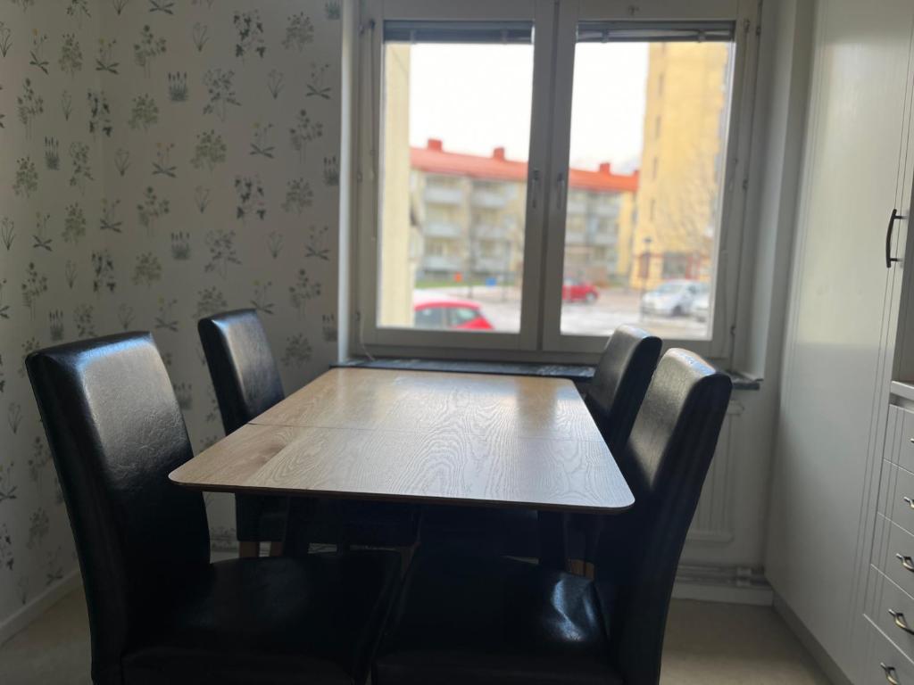 uma mesa e cadeiras num quarto com uma janela em LHM em Borås