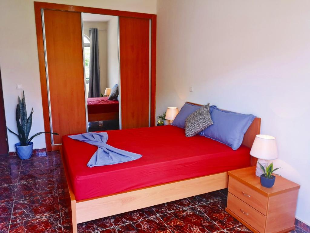 1 cama roja grande en una habitación con espejo en Excelente localización en Praia en Praia