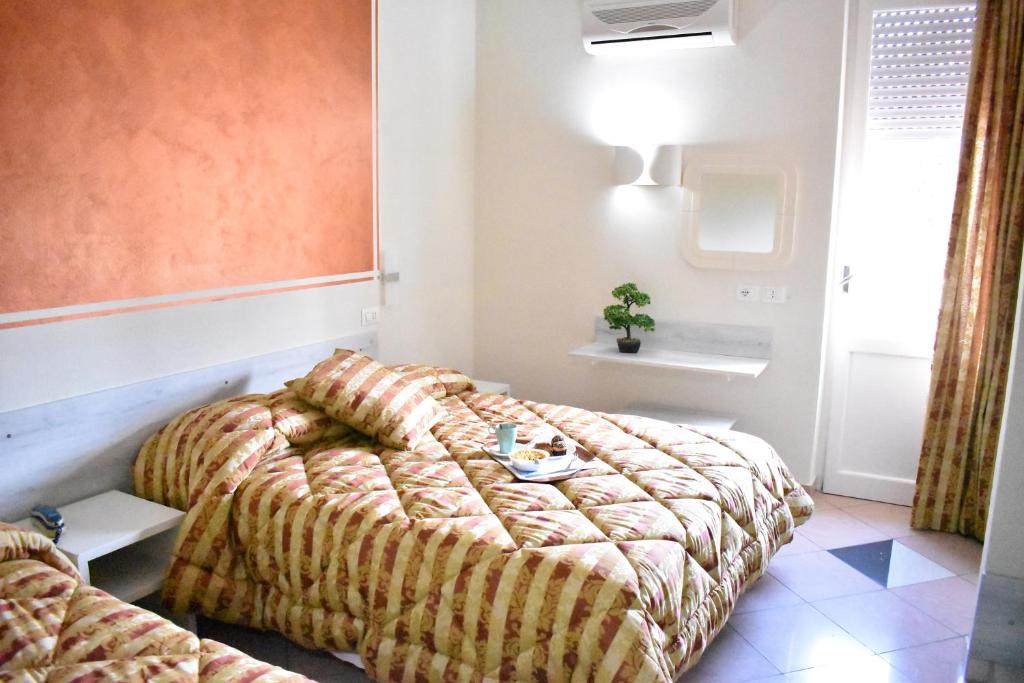 グロッセートにあるHotel Il Parcoのベッドルーム1室(ベッド2台付)