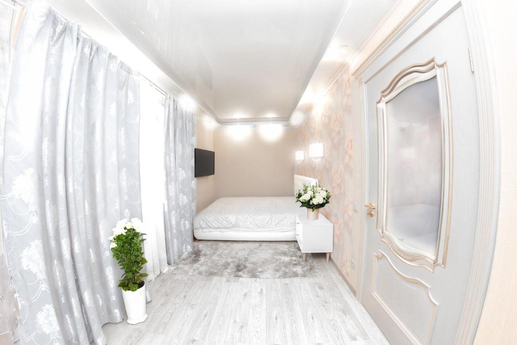 um pequeno quarto com uma cama e um espelho em Центр Яворницкого с Джакузи em Dnipro