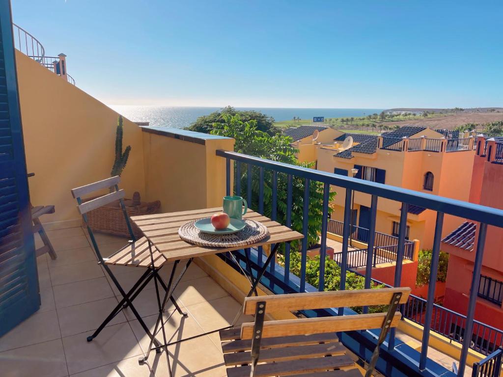 a balcony with a table and chairs and the ocean at Meloneras by the sea in San Bartolomé