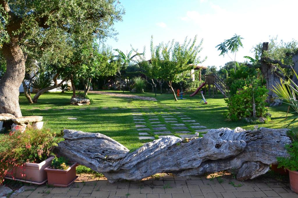 a large tree log sitting in a park at B&B SanteBice in Polignano a Mare