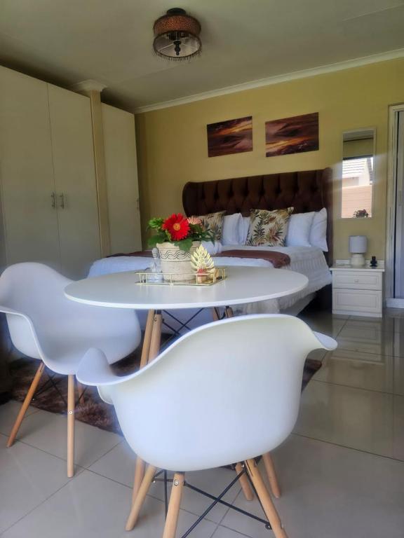 a living room with a table and chairs and a bed at MorningMist Boutique Sun in Centurion