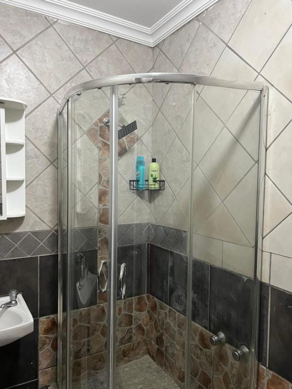 una ducha con puerta de cristal en un baño en MorningMist Boutique Sun, en Centurion