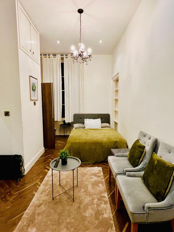 a bedroom with a bed and a couch and a table at STYLISH 1Bhk HEART OF THE CITY in Edinburgh