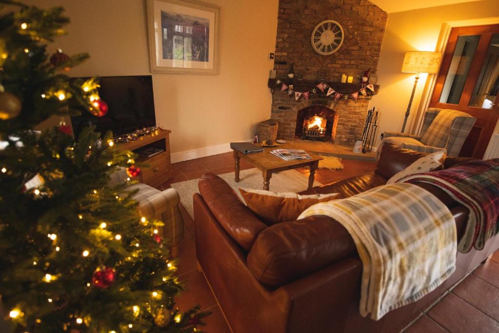 a living room with a christmas tree and a fireplace at The Coach House in Martin