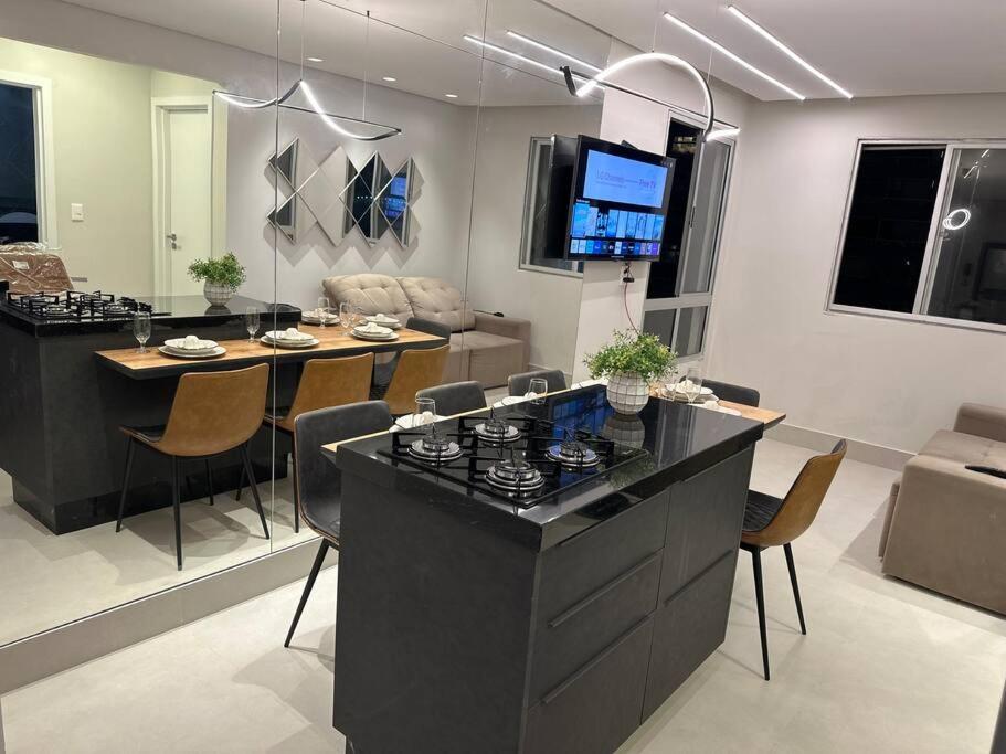 eine Küche und ein Wohnzimmer mit einem Tisch und einer Couch in der Unterkunft Apartamento Frente Mar Bc 704 in Balneário Camboriú