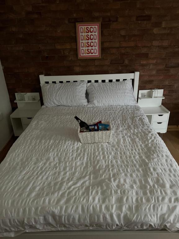 諾里奇的住宿－Hidden Havens，一张白色的床,上面有一篮书