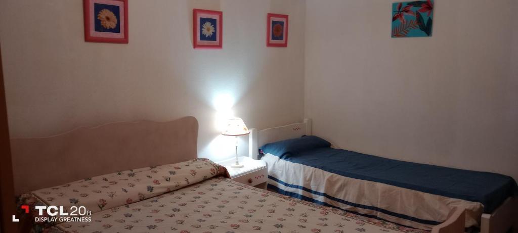 sypialnia z 2 łóżkami i lampką na stole w obiekcie Hospedaje LA LUCIA w mieście Almafuerte