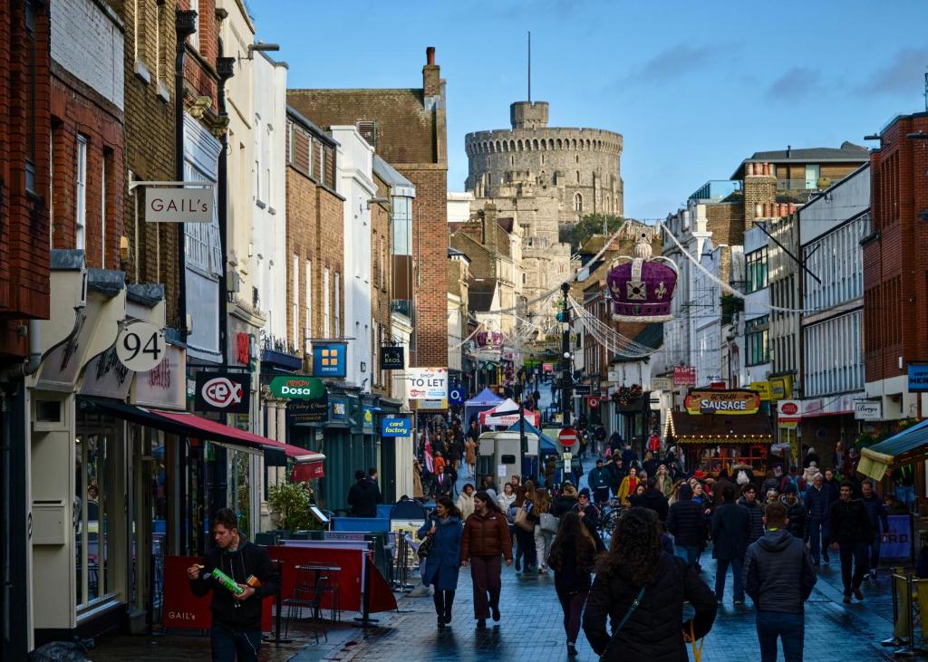 uma multidão de pessoas andando por uma rua movimentada da cidade em Queen Annes court luxury apartment on high street em Windsor