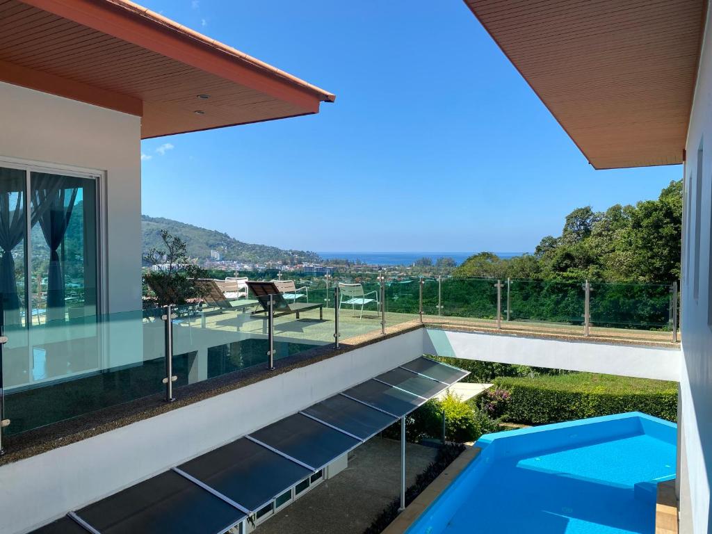 卡馬拉海灘的住宿－卡馬拉海伊特別墅，从带游泳池的房屋阳台欣赏风景