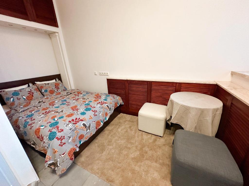 a bedroom with a bed and a table and a chair at Cozy 33m2 2-room Studio Apartment in City Center in Rīga