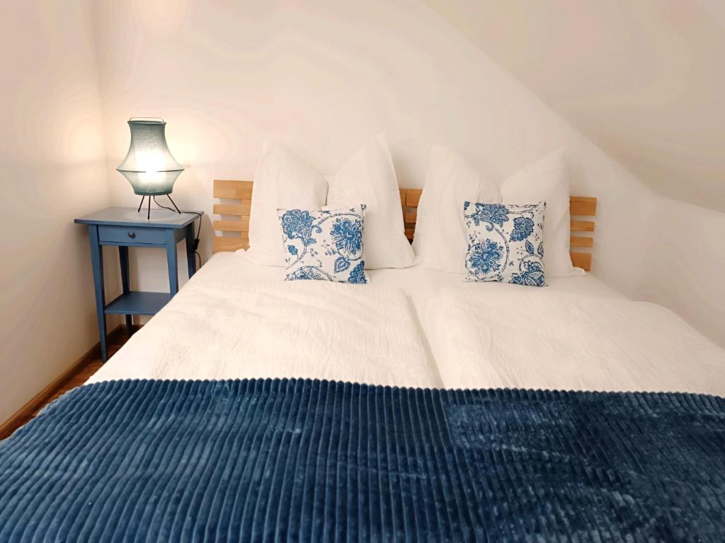 a bedroom with a bed with blue and white pillows at Cozy Stay Apartments in Salzburg