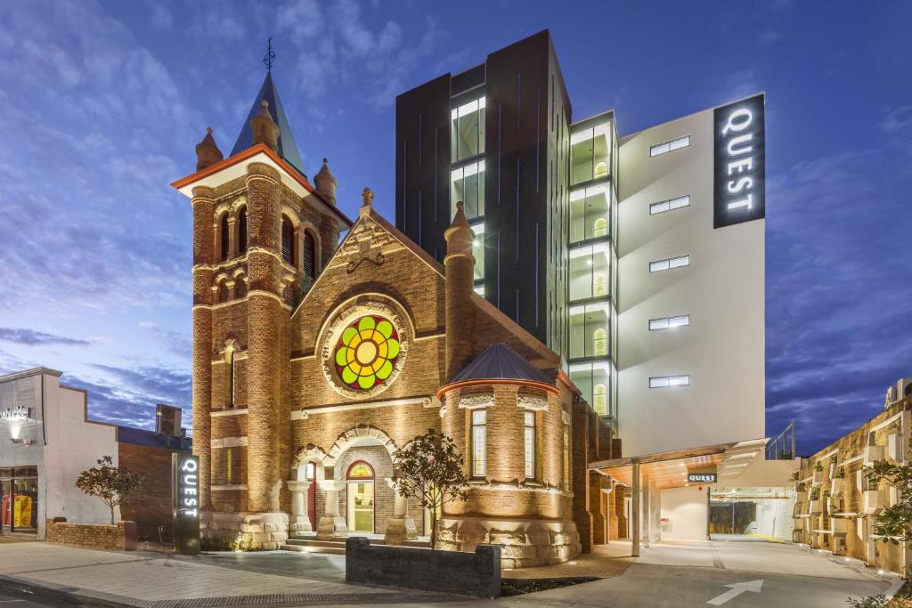 una iglesia con una torre de reloj al lado de un edificio en Quest Toowoomba, en Toowoomba