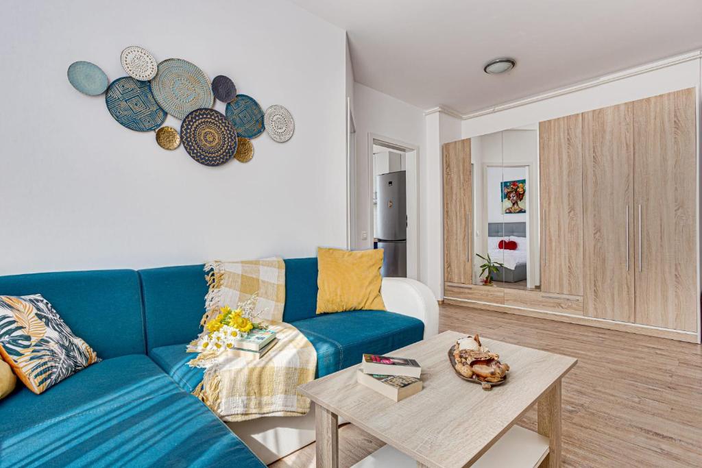 a living room with a blue couch and a table at Dodi Blue Apartament in Arad