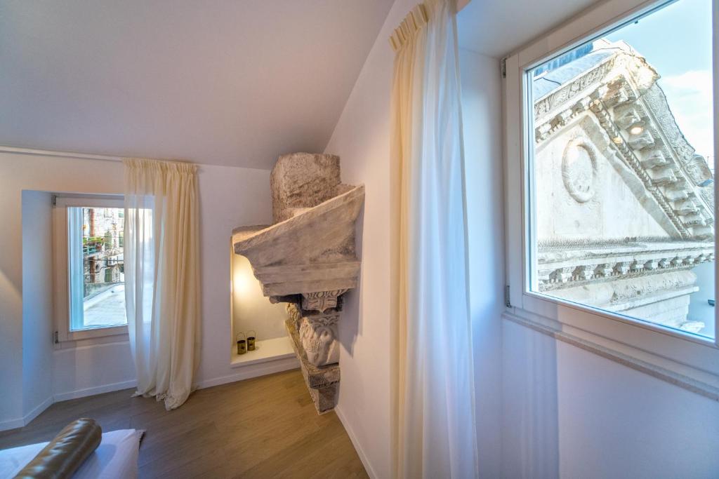 Zimmer mit einem großen Fenster und einer Steinsäule in der Unterkunft Apartment Roman Heritage in Split