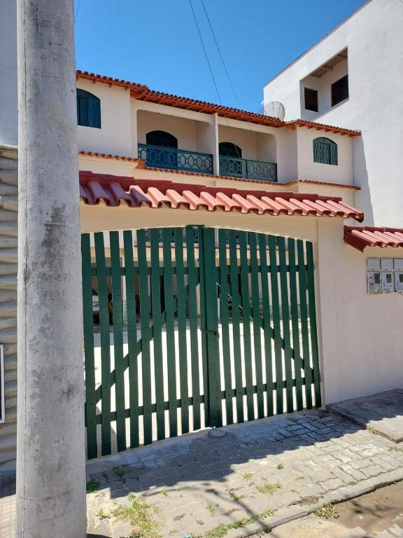 a house with a green gate in front of it at Hospedagem Familiar in Piúma