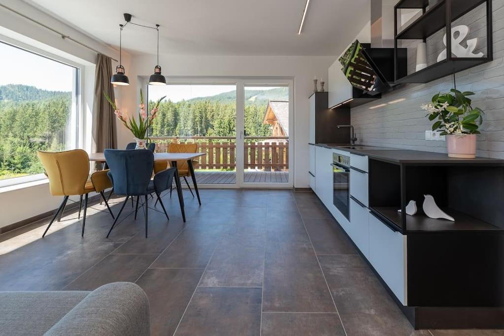 una cucina e una sala da pranzo con tavolo e sedie di Appartement Tannenhof III a Ramsau am Dachstein