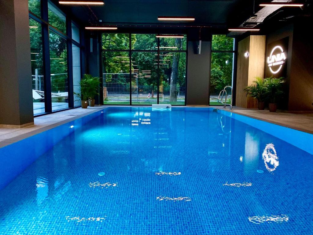 duży basen z niebieską wodą w budynku w obiekcie APARTAMENTY ARTE LUBLIN Studio Unia Art Residence 118 garaż w mieście Lublin