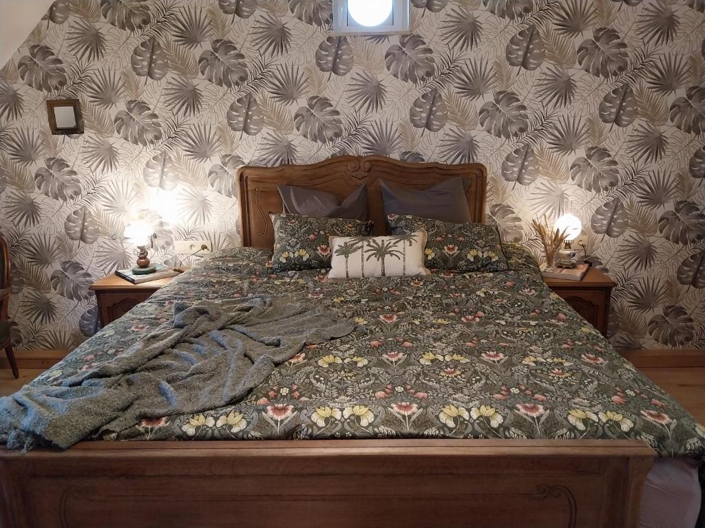 1 dormitorio con 1 cama con manta y almohadas en La grange aux dîmes en Walcourt