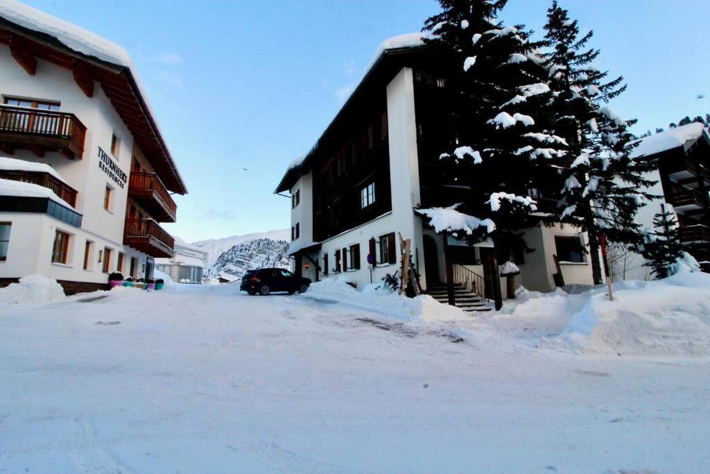 un bâtiment recouvert de neige avec un arbre devant lui dans l'établissement Skilounge Zürs direkt beim Skilift, à Zürs