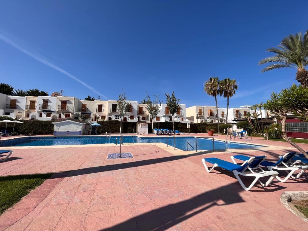 einen Pool mit Liegestühlen neben einem Resort in der Unterkunft Palm View Apartment Vera Coast in Playas de Vera