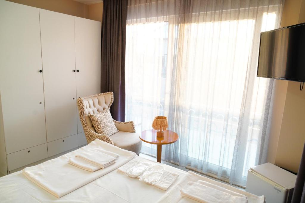 a bedroom with a bed and a chair and a window at LARA BOUTIQUE HOTEL Antalya in Lara