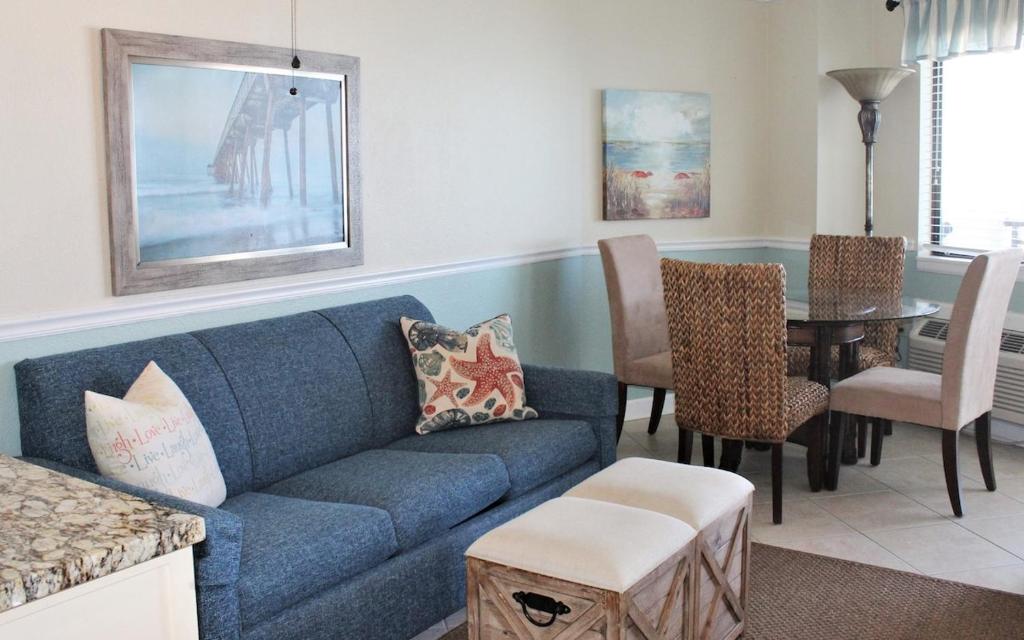un salon avec un canapé bleu et une table dans l'établissement Blue Water Oceanview, 15th floor, à Myrtle Beach