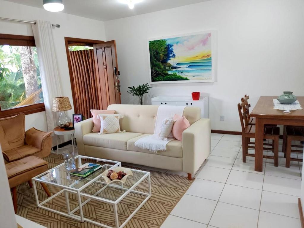 uma sala de estar com um sofá e uma mesa em Flat Sol do Ipanema em Itacaré