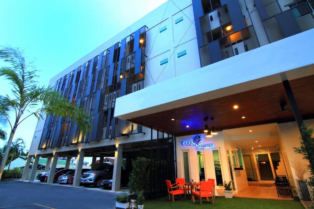 a hotel with red chairs in front of a building at Cool Residence - SHA Plus in Phuket Town