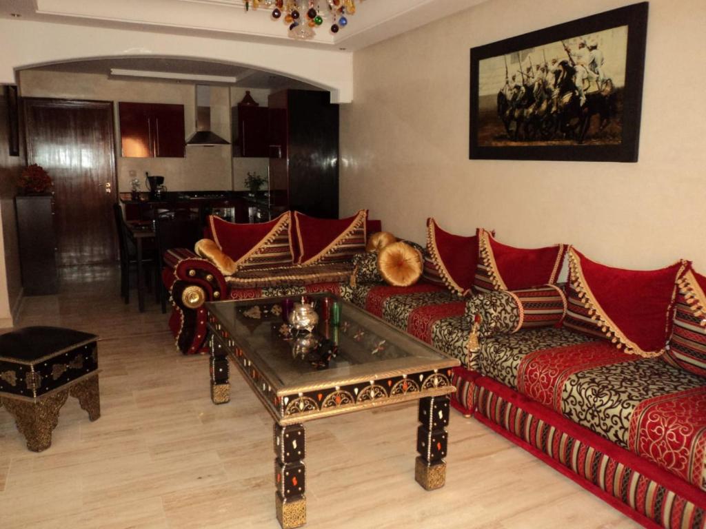 een woonkamer met rode banken en een tafel bij Cosy appartement only family à Gueliz in Marrakesh