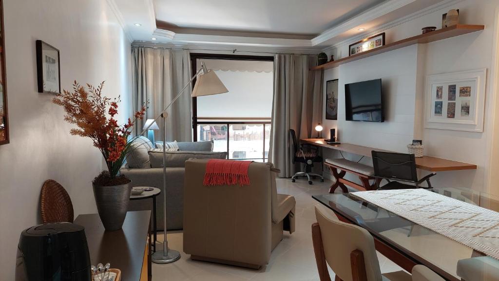 uma sala de estar com um sofá e uma sala de jantar em Apartamento aconchegante. no Rio de Janeiro