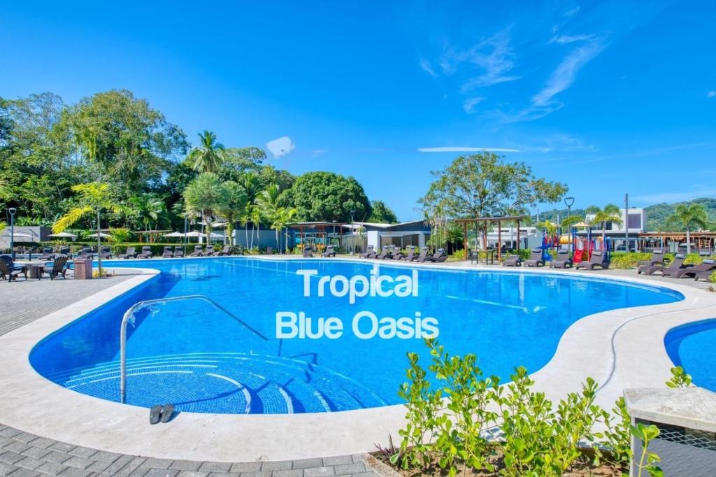 ein Pool in einem Resort mit einem blauen Kostenschild in der Unterkunft Tropical Blue Oasis in Puntarenas