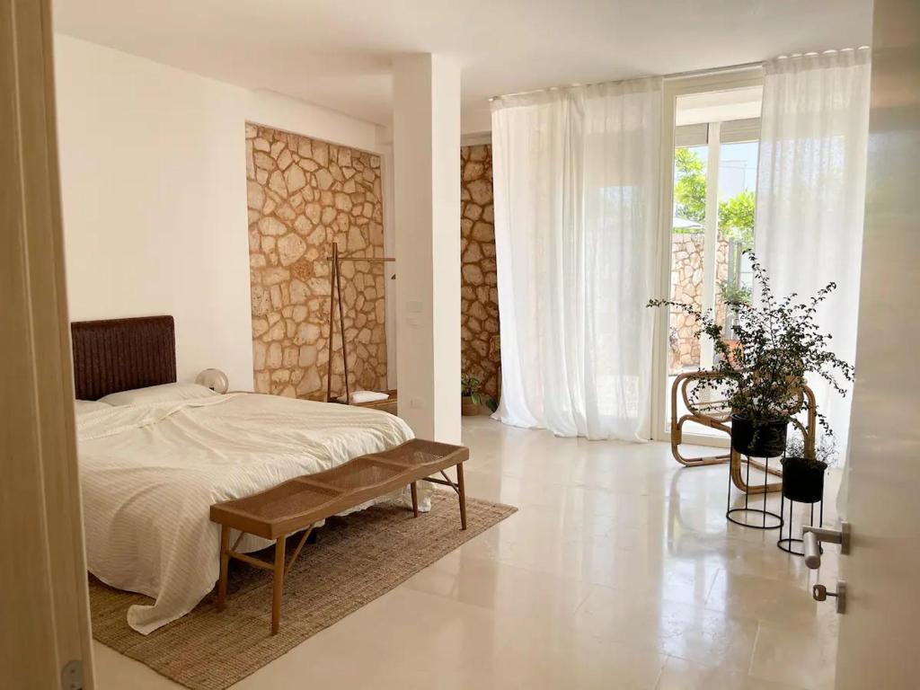 une chambre avec un lit, une chaise et une fenêtre dans l'établissement Apulian Vibes modern villa, à Ostuni